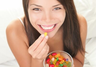 Woman-Smiling-Eating-Gummies-Candy